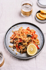 Arroz con verduras y azafran, spanish dish. Vegetarian risotto with  vegetables, champignons and saffron on beige linen tablecloth. Selective focus