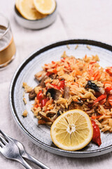 Arroz con verduras y azafran, spanish dish. Vegetarian risotto with  vegetables, champignons and saffron on beige linen tablecloth. Selective focus