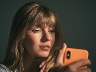Closeup indoor portrait of stunning pretty girl taking selfie trendy style,funny positive emotions long blond hair evening natural light sun