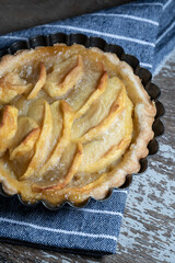 Small homemade apple pie on rustic background