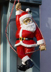 Santa coming down a rope on a building.