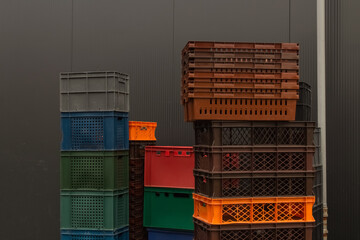 A stack of folded multi-colored plastic boxes at the back entrance 