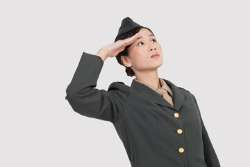 Obraz na płótnie Canvas Confident female military officer saluting over gray background
