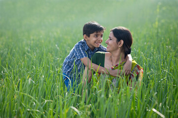 Happy mother and son at agricultural field