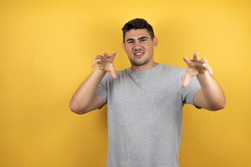 Young handsome man wearing a casual t-shirt over isolated yellow background smiling funny doing...