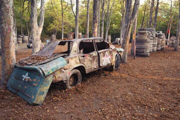 Old rusty and abandoned car at the paintball base