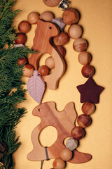 Cute wooden baby toys on yellow background. dragon, dinosaur, beanbag and beads. Eco accessories, beanbag and teethers for newborn. Flat lay, top view