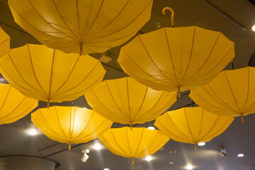 Yellow color umbrella hang upside down in ceiling.