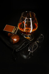 Glass of cognac and smoking pipe