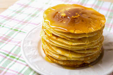 Homemade of breakfast pancakes with honey on the white plate