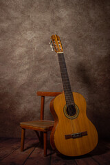 Obraz na płótnie Canvas Acoustic guitar on a stool. Musical instrument. Spanish guitar.