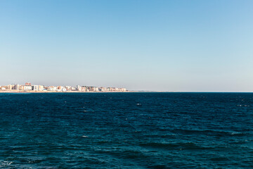 Sea waves and a city in the background