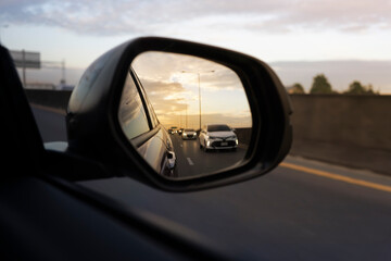 car view mirror on sunset. sunset car driving scene.