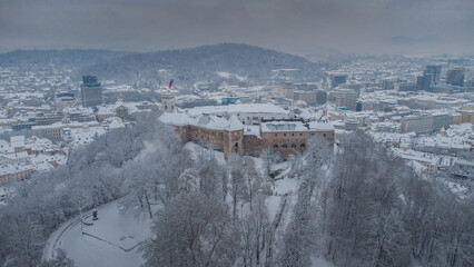 Winter aerial panorama of the city of Ljubljana with Castle as the highlight in the centre. Downtown Ljubljana Slovenia covered with snow.
