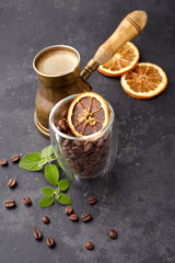 Coffee, coffee  beans with dry orange, melissa  leaves on black background.
