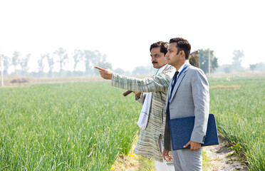 Businessman discussing with farmer on agriculture field