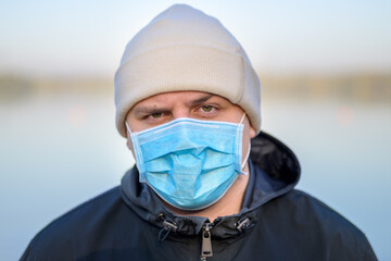 Thoughtful young man wearing protective face mask