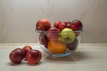 Lots of apples in a transparent cup on the kitchen table 