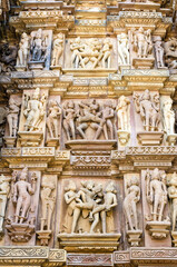 Fototapeta na wymiar Sculptures carved on the facade of Khajuraho Hindu temples, India 