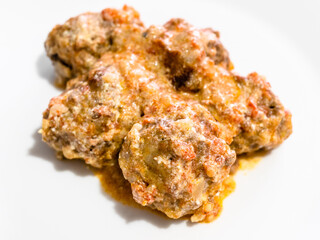 portion of meatballs with rice on white plate close up