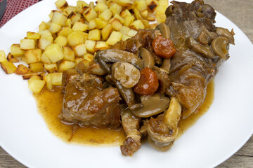 assiette de coq cuisiné à la bière et pommes de terre rissolées sur une table