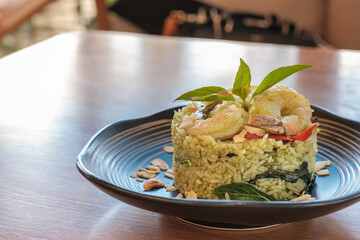Shrimp pesto rice in white plate on wooden table. enjoy eating concept.
