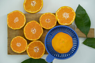 Delicious fresh squeezed tangerine juice in a transparent glass. Peeled sliced mandarin orange close up pieces.