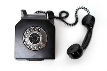 vintage black telephone set with dialing dial in retro style on white background, concept of old...