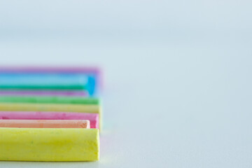 Close up of colorful chalks on white background; colors; school; rainbow colors; paint and write