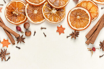 Dry orange slices, cinnamon sticks,anise on a light background with space for text.