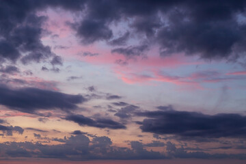 Naklejka na ściany i meble Dramatic beautiful sunrise, sunset pink violet blue sky with dark storm clouds background texture