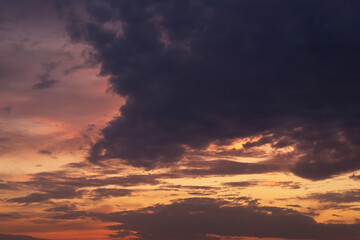 Epic dramatic sunset, sunrise on storm sky with dark clouds, orange yellow red sunlight