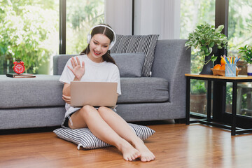Businesswoman waving hands to greeting Business team in video conference at her home. Webinar, social distancing, e learning and seminar online Concept.