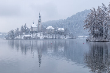 Bled lake in wintertime, scenic view of Bled Island in snow and fog, Slovenia.
