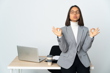 Young latin business woman working in a office isolated on white background in zen pose