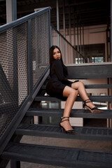 Girl in fashionable black casual clothes on a background of a stone wall, modern urban...