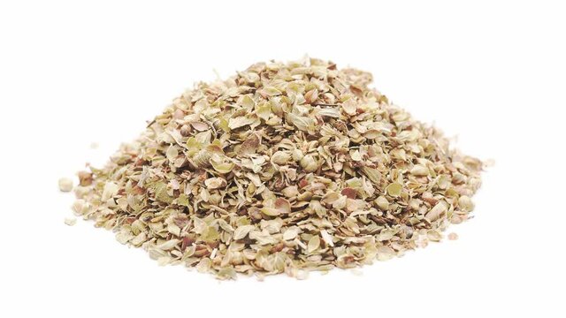 Close-up view of a heap of dried oregano, isolated on white, seamless loop rotation
