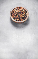 Fruit loose dry tea herbs or leafs in a bowl on gray table with blank free space for your advertising or text