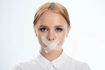 Face of woman with taped mouth