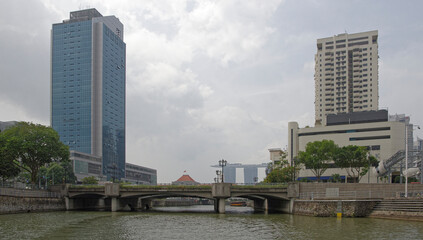 View of the Coleman Bridge on the Singapore River. On the bridge, pedestrians, on the river ship