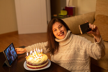 Woman celebrating her birthday by video calling with her family.
