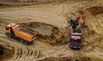 excavator moving earth and unloading into a dumper truck © Med Photo Studio