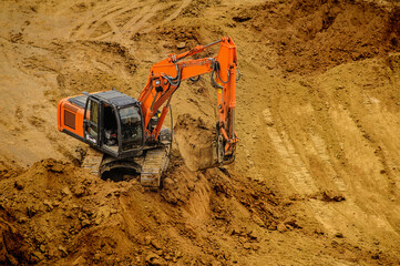 excavator moving earth and unloading into a dumper truck