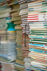  Stacks of old discarded school textbooks waiting to be disposed of in a school library.
