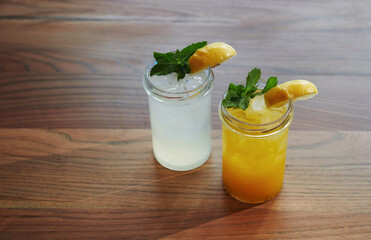 Fototapeta premium Yellow and green colored. Close up view of fresh summer alcoholic cocktails on the wooden table