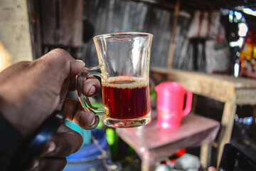 A cup of a raw tea holding