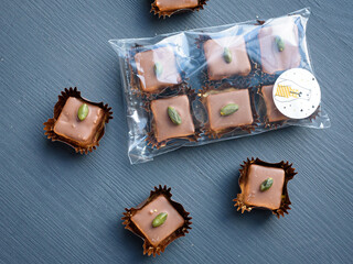 Chocolate candies with pistachio marzipan filling  beautifully packaged with whole nut pistachios. Natural lihgt