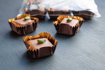 Chocolate candies with pistachio marzipan filling  beautifully packaged with whole nut pistachios. Natural lihgt