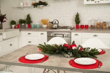 New Year's decor of modern kitchen in Scandinavian style. Serving a white plate on a red rustic napkin with a close-up and copy space. Hygge kitchen details New year concept. Selective focus