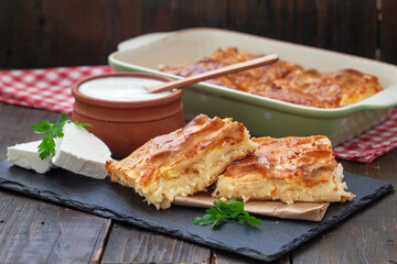 Homemade Traditional Serbian Gibanica with cheese. Delicious soft cheese pie, cut and layed on backing paper